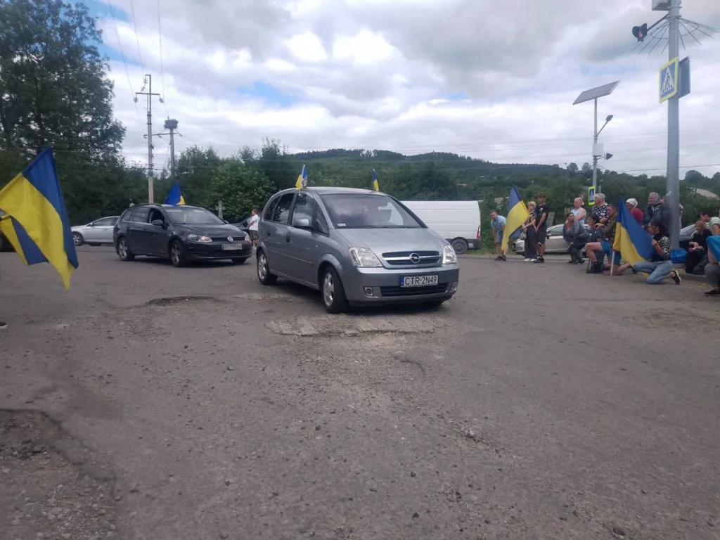 Автоколона з українськими прапорами на дорозі