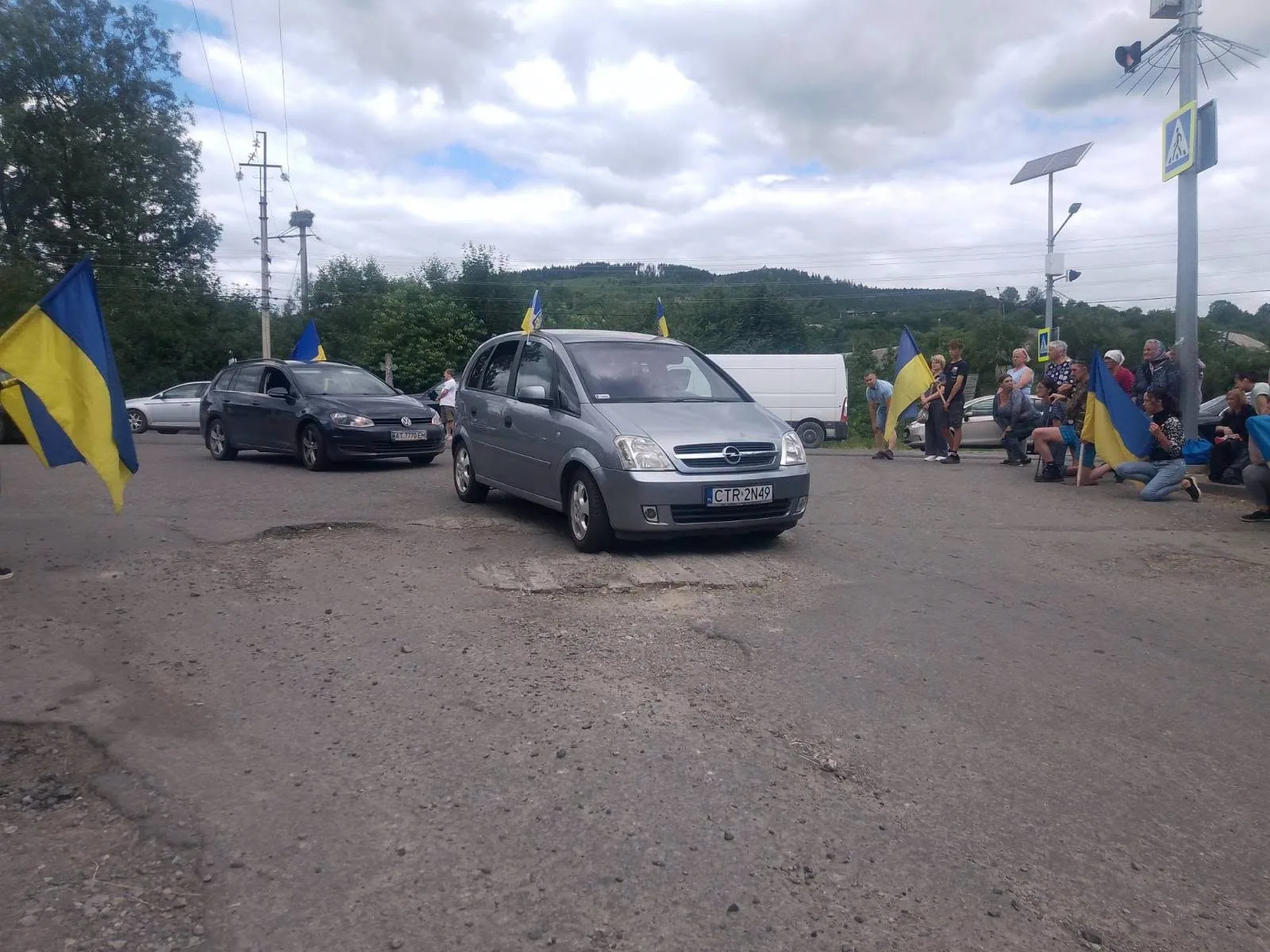 Автоколона з українськими прапорами на дорозі