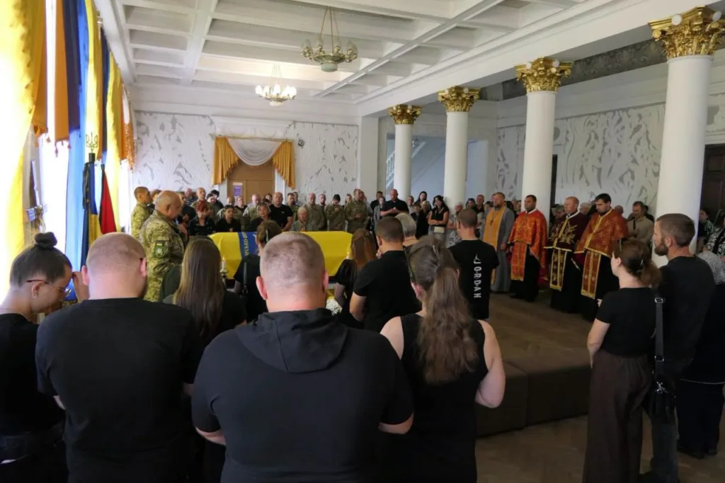 Прощання з військовим у залі з прапорами України