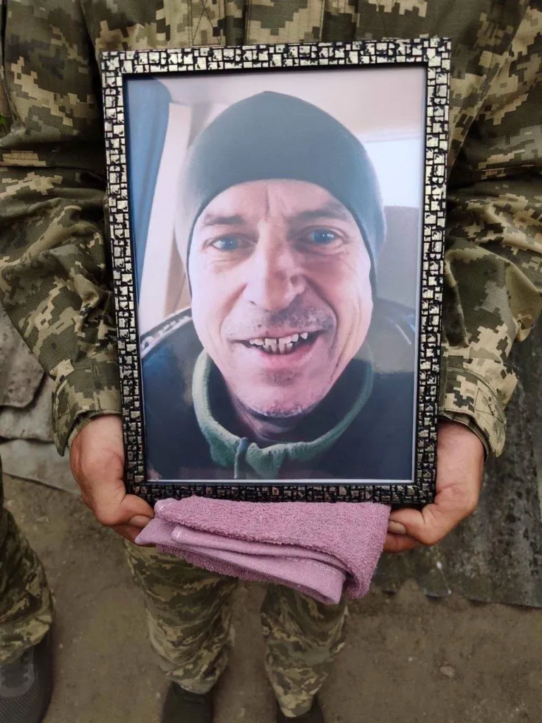Військовий тримає фото чоловіка у рамці