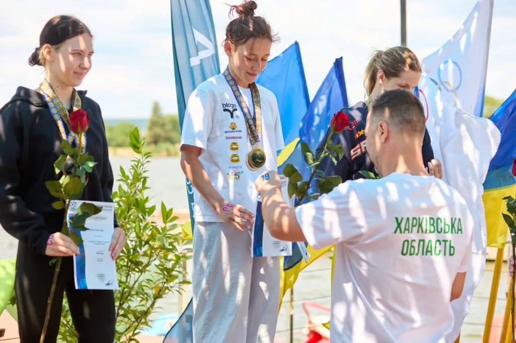 Нагородження спортсменок медалями біля водойми