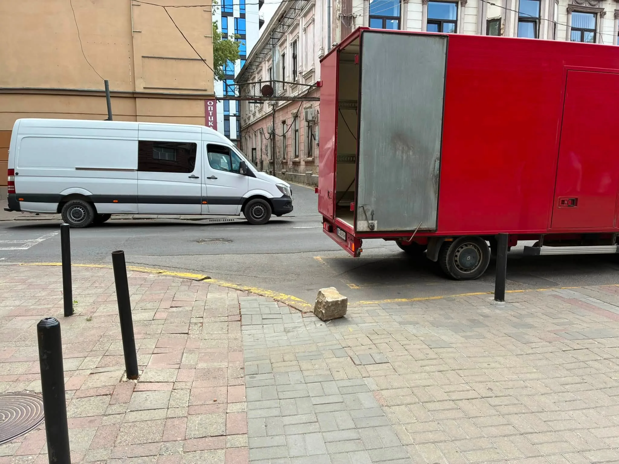 Білий і червоний фургони на міській вулиці