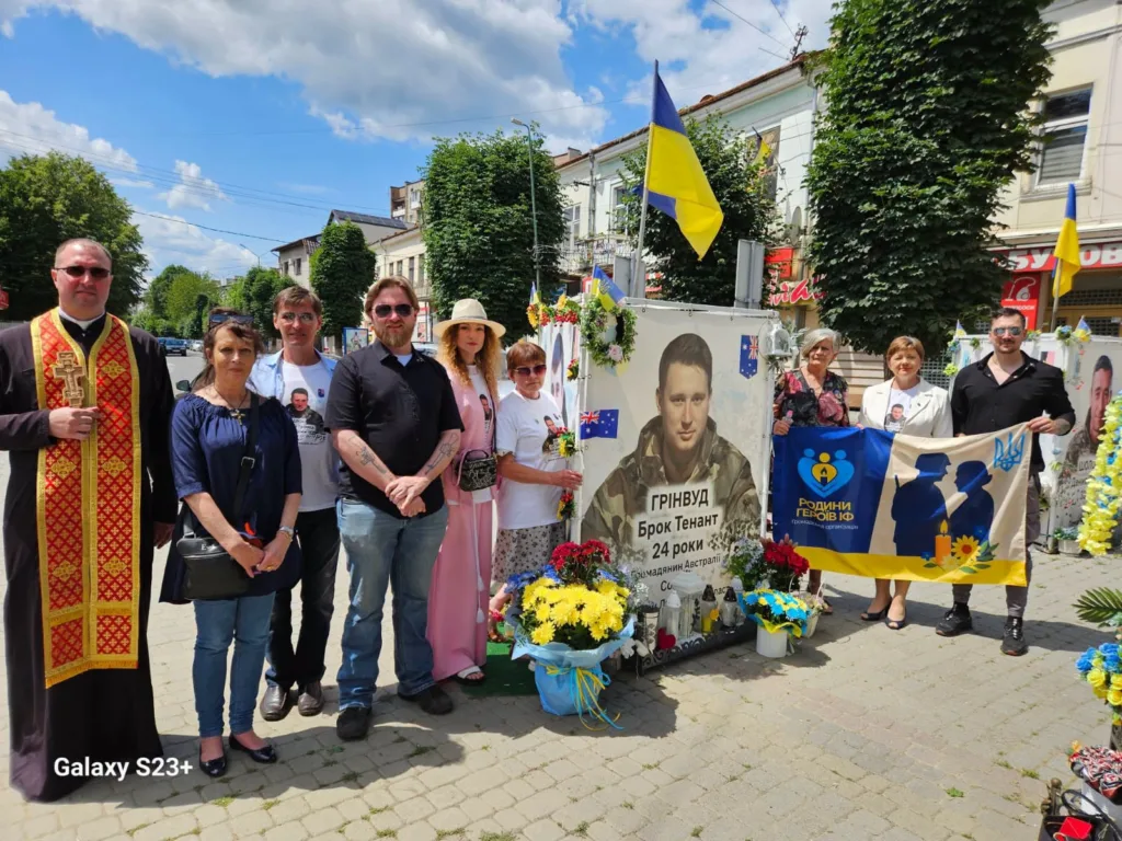 Люди вшановують полеглого воїна біля меморіалу