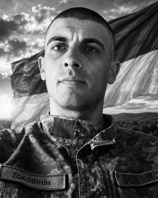 Український військовий перед прапором України