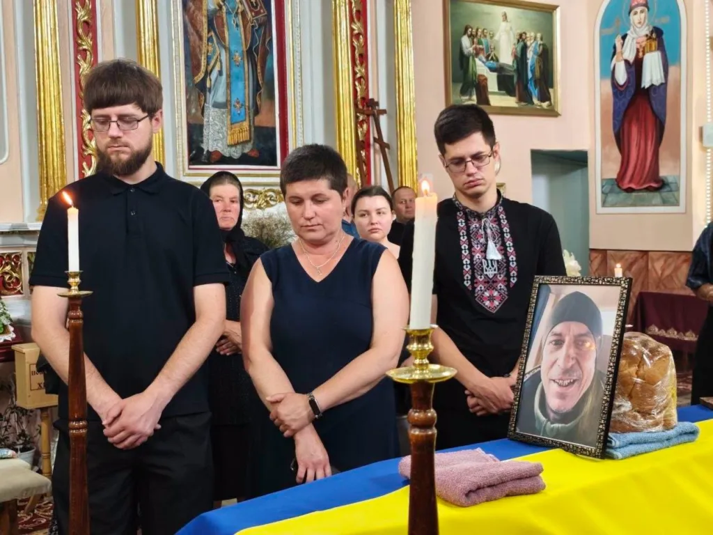 Люди прощаються з померлим у церкві