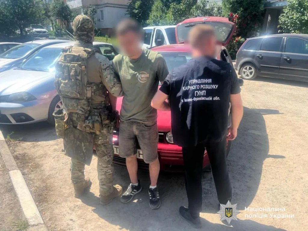 Поліція затримує підозрюваного біля автомобіля