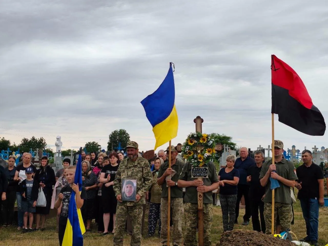 Похорон воїна з українським і червоно-чорним прапорами