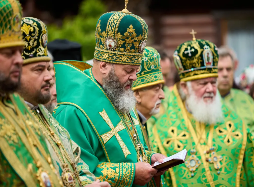 Православні священники у зелених рясах під час служби
