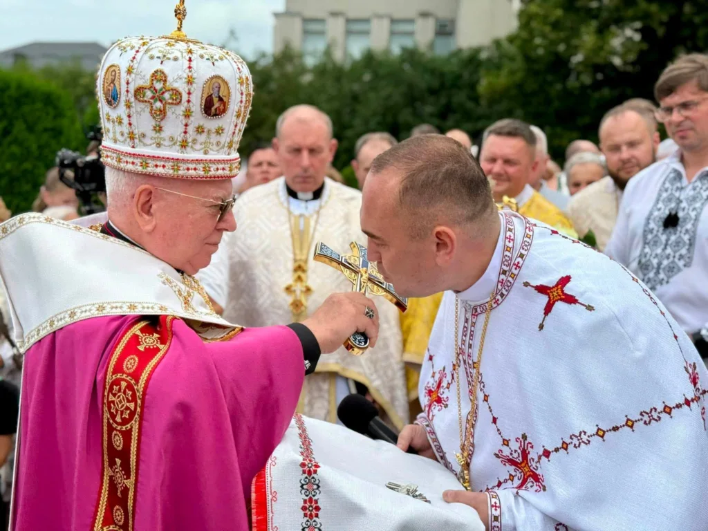 Священник цілує хрест під час церемонії