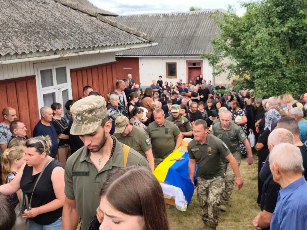Військові несуть труну, накриту прапором України