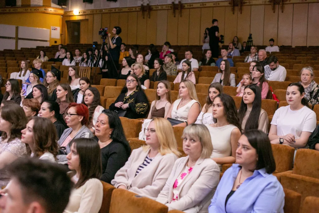 Люди сидять у залі під час заходу