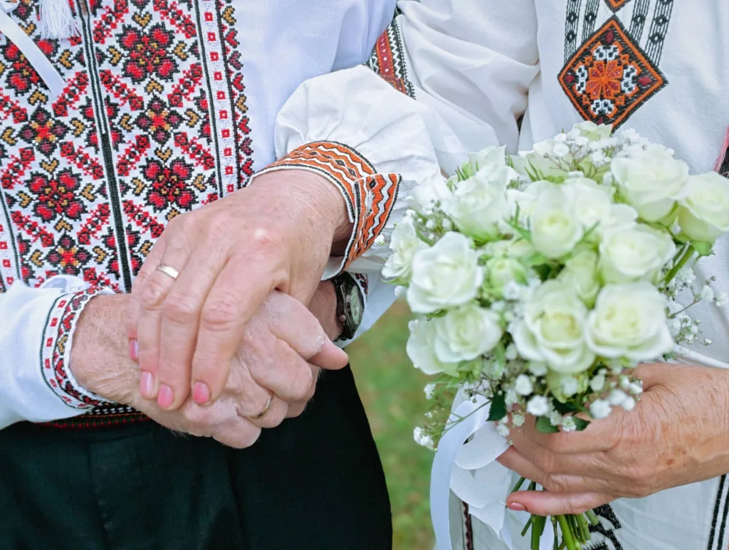 Пара у вишиванках тримає руки та букет