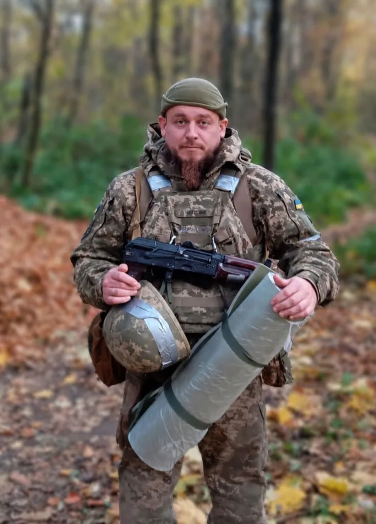 Український військовий у лісі з спорядженням