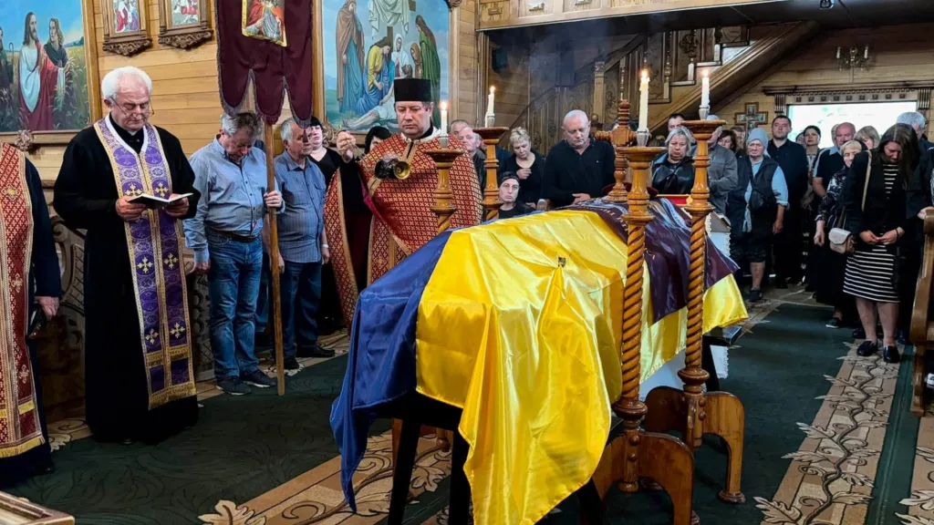 Похоронна церемонія в церкві з українським прапором