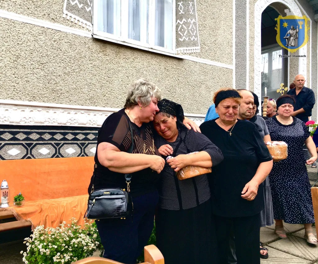 Люди сумують біля будинку під час прощання