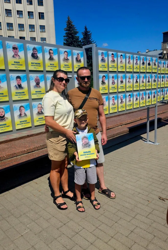 Сім'я біля меморіальної стіни героїв України