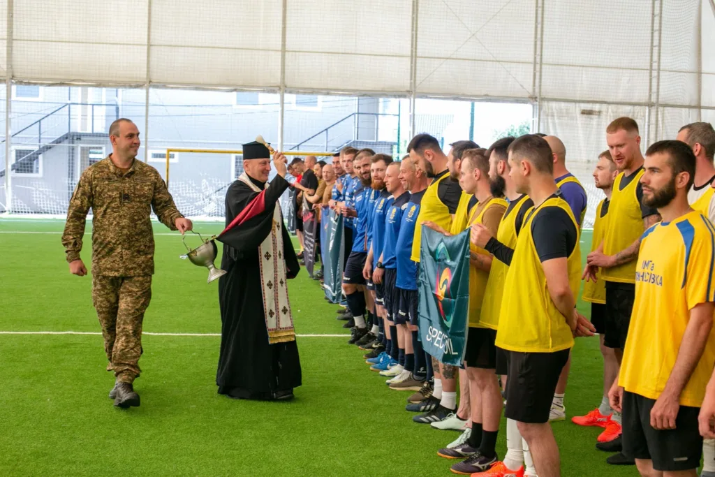 Священник благословляє футбольних гравців перед матчем
