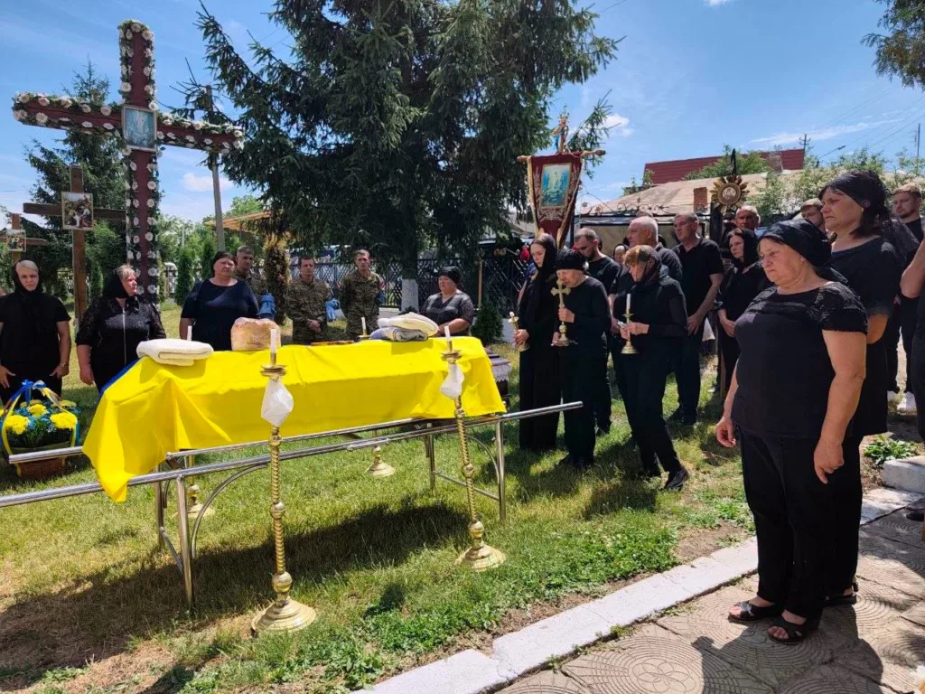 Похоронна церемонія з труною у жовто-синьому прапорі