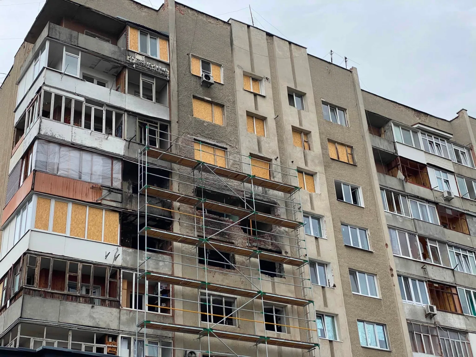 Пошкоджений житловий будинок з риштуванням для ремонту