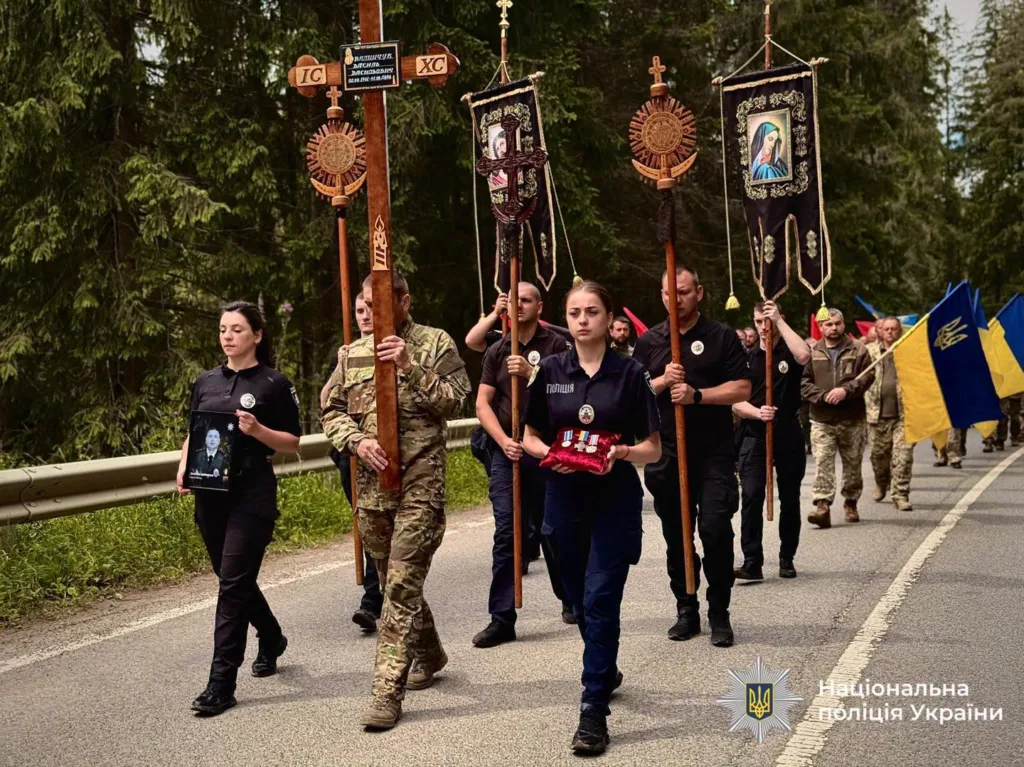 Поліцейські несуть хрест і прапори під час церемонії
