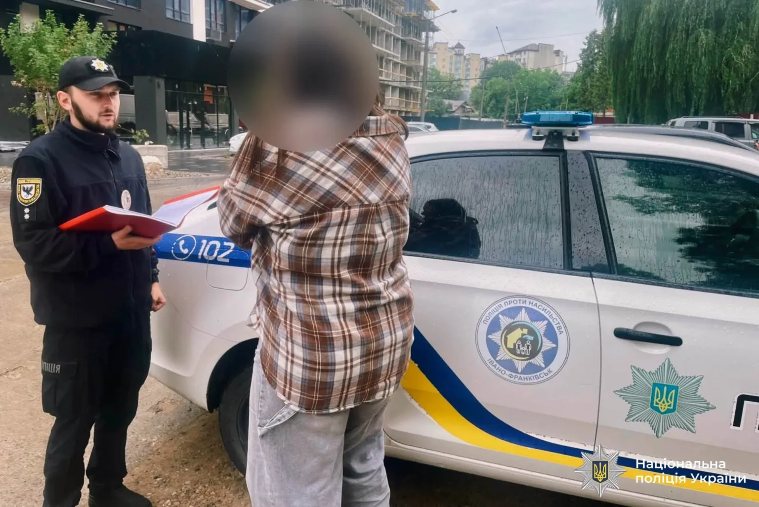Поліція спілкується з людиною біля патрульного авто