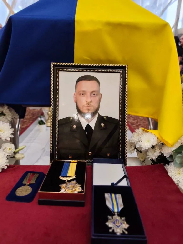 Фото військового з медалями та прапором України