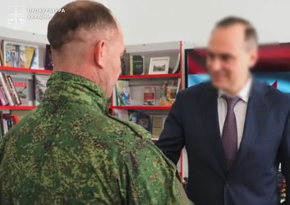 Військовий тисне руку чоловікові у костюмі