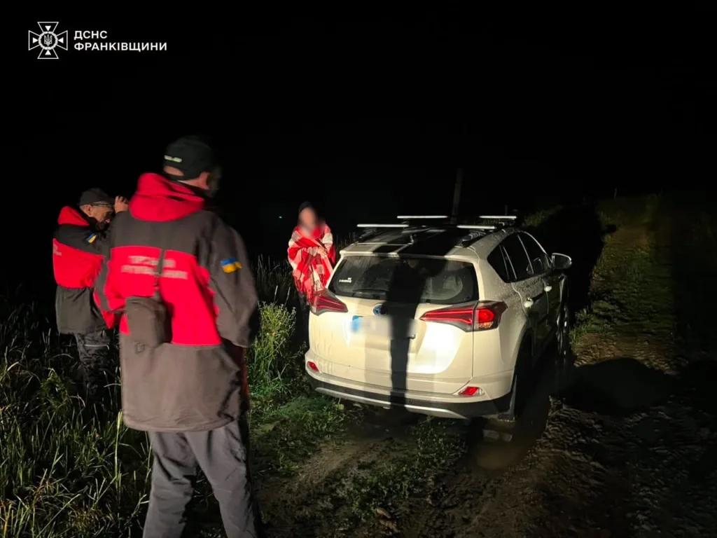Рятувальники біля автомобіля на темній дорозі