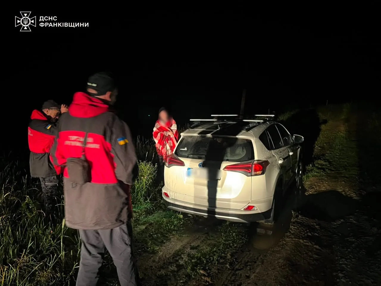 Рятувальники біля автомобіля на темній дорозі