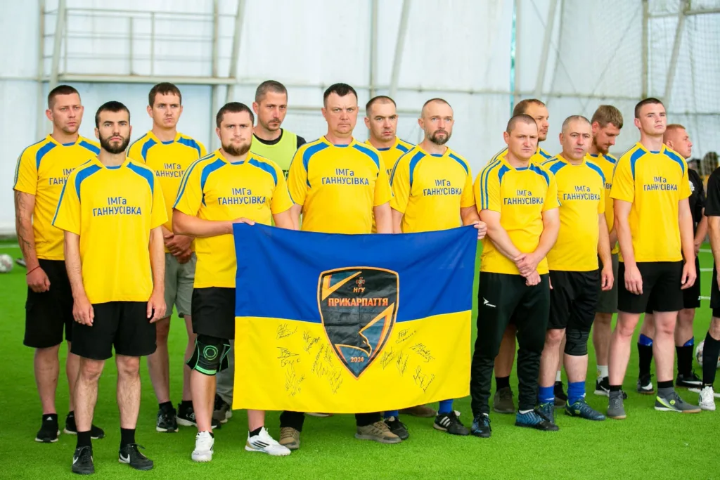 Футбольна команда у жовтих формах з прапором України