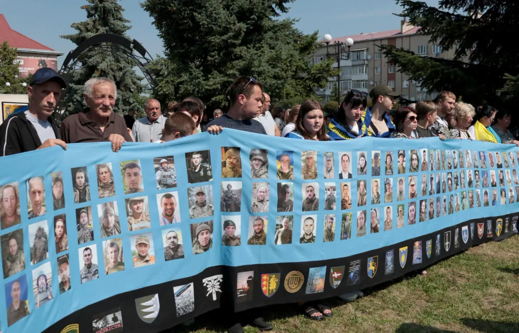 Люди тримають банер із фото українських військових