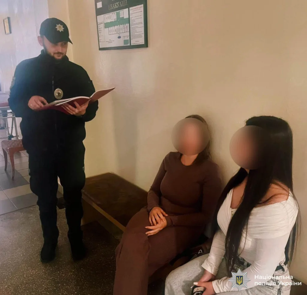 Поліцейський спілкується з двома жінками у приміщенні