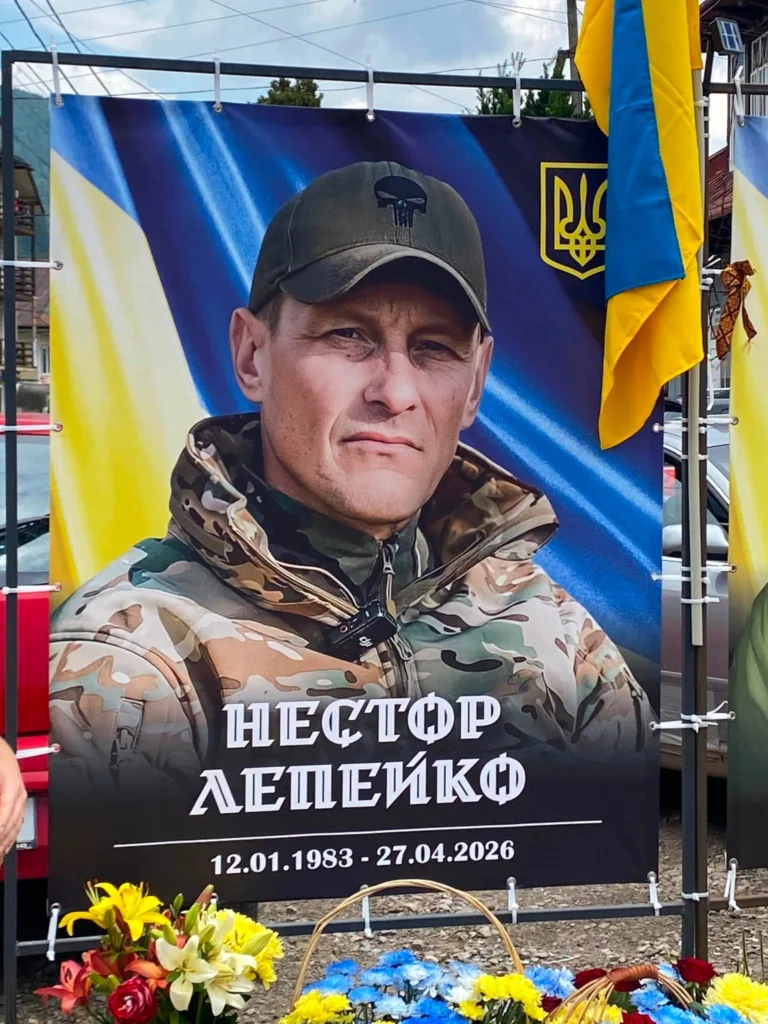 Портрет українського військового на фоні прапора