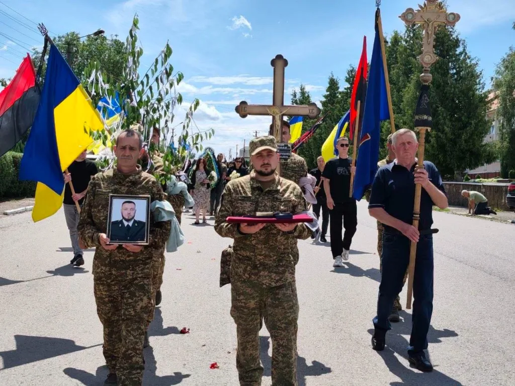 Похоронна процесія військових із українськими прапорами