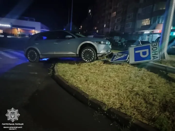 Авто на газоні біля поваленого дорожнього знаку