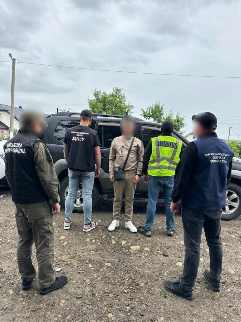 Поліцейські та військові затримують підозрюваного біля авто