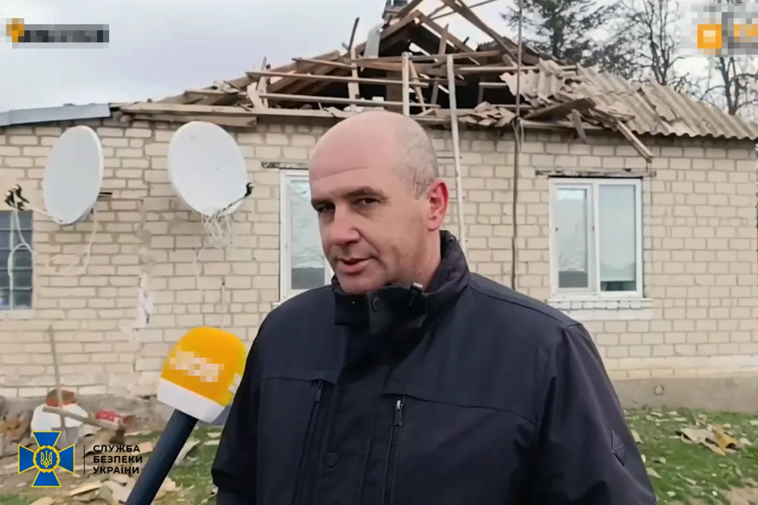 Чоловік дає інтерв'ю біля зруйнованого будинку