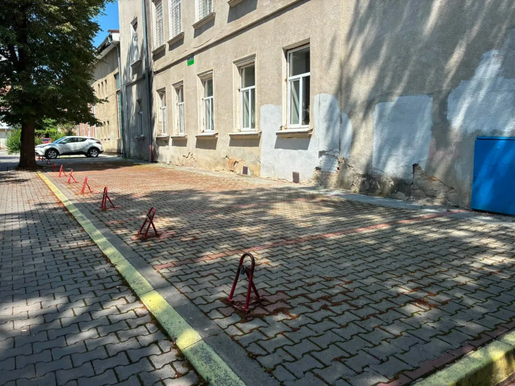 Порожній паркінг біля будівлі з червоними обмежувачами