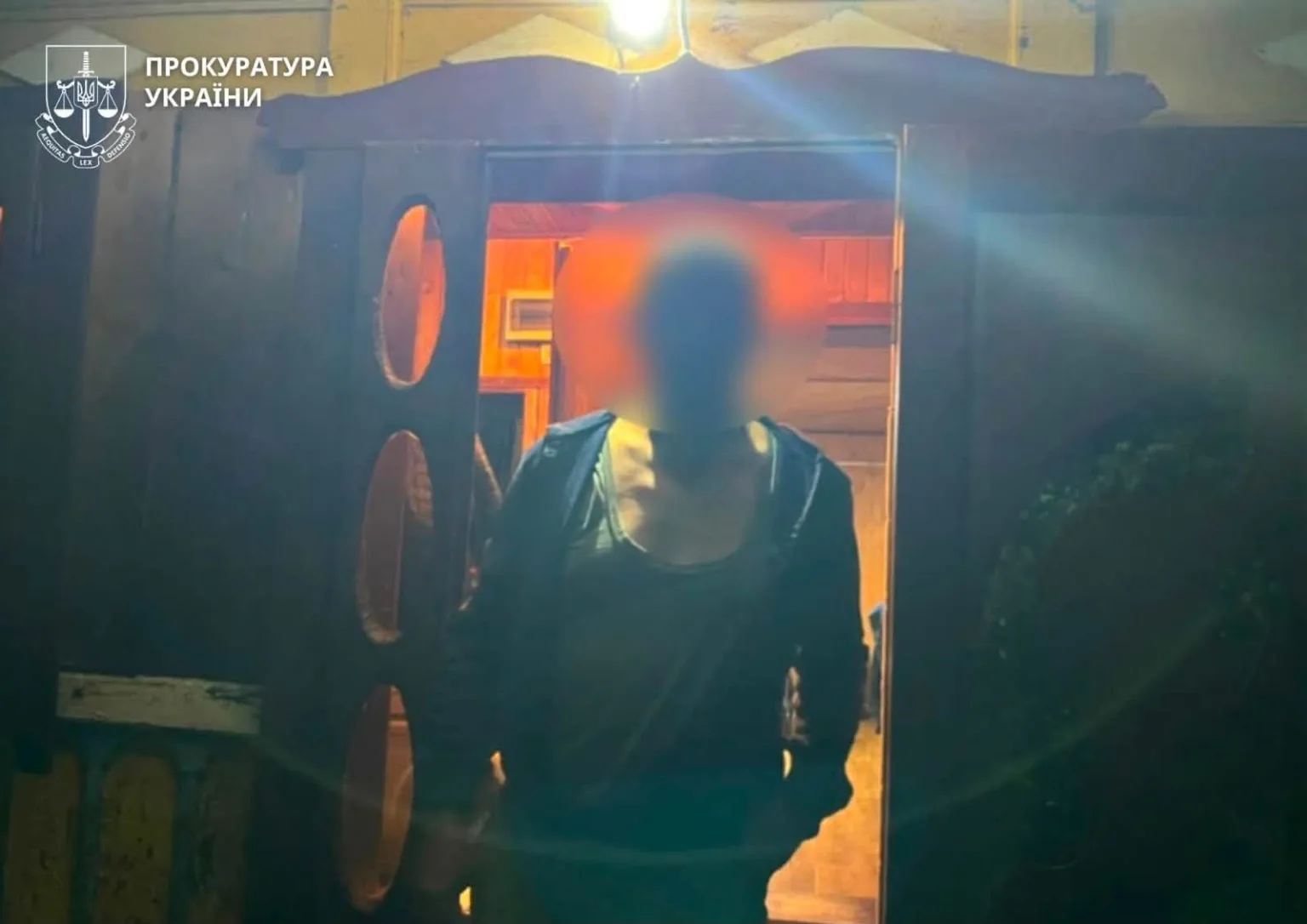 Людина стоїть у дверях під вивіскою прокуратури України