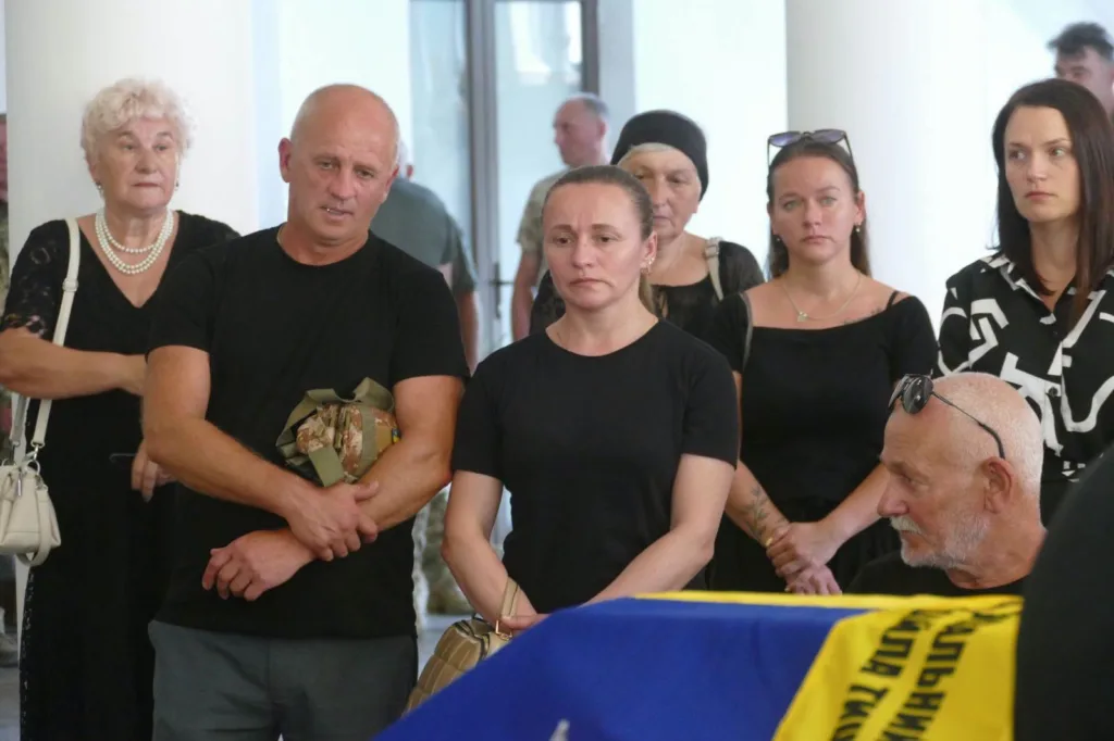Люди прощаються із загиблим військовим під прапором України