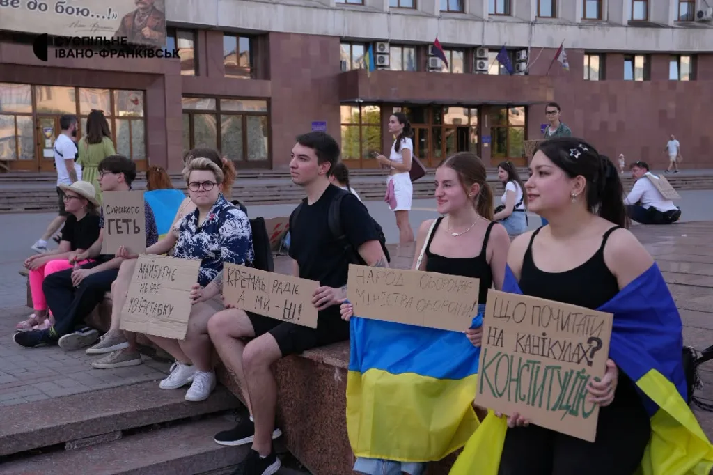 Молодь протестує з плакатами та прапором України
