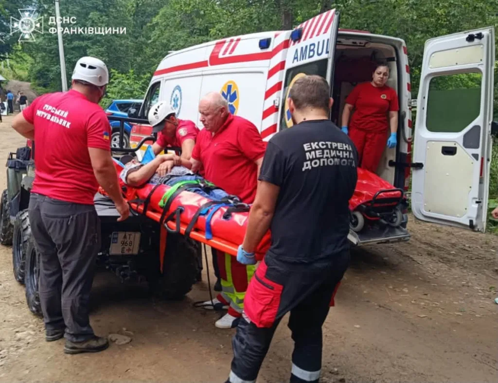 Рятувальники переносять постраждалого до швидкої допомоги