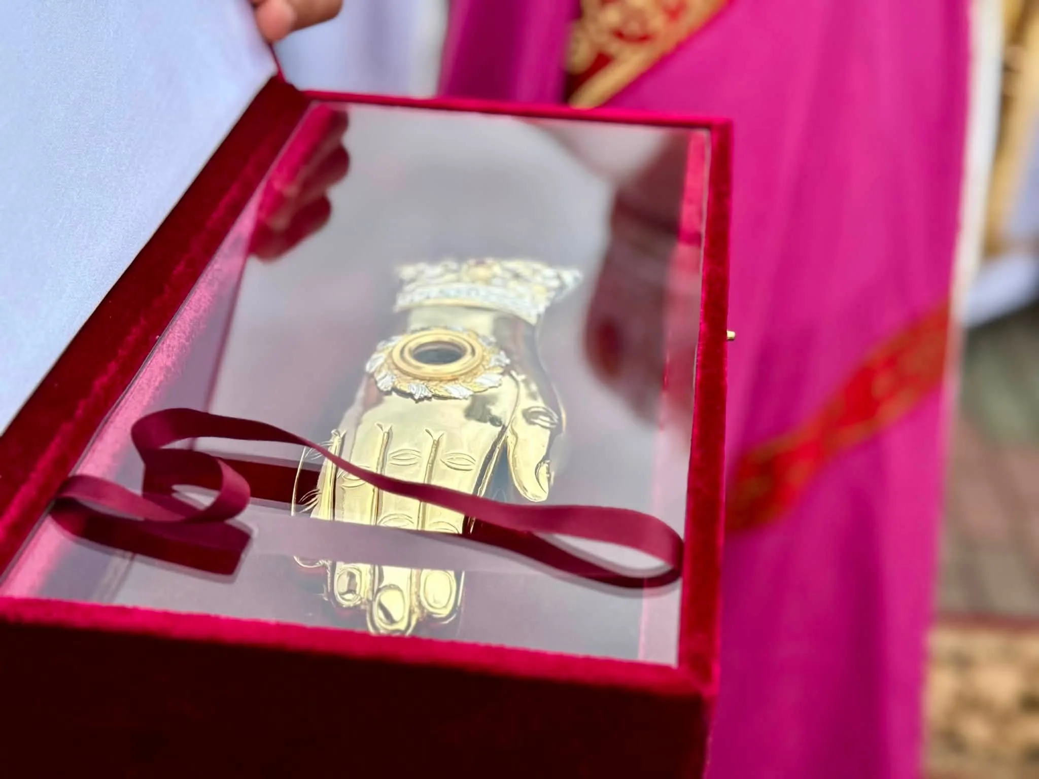 Золота реліквія руки в оксамитовій коробці