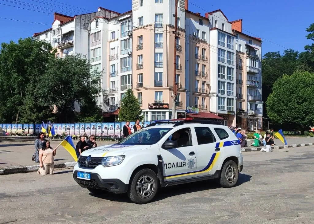Поліцейська машина на площі з прапорами України