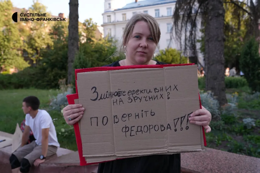 Жінка тримає плакат із протестним написом