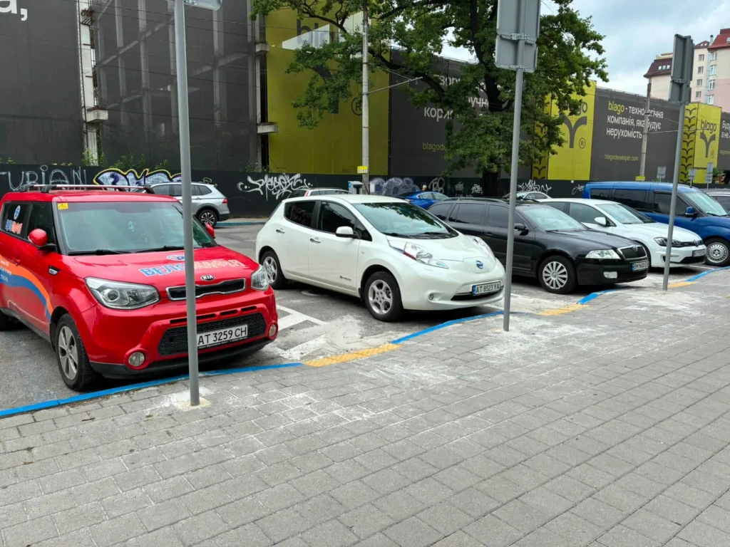 Ряд припаркованих автомобілів біля будівлі міста