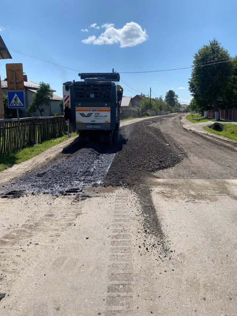 Дорожня машина ремонтує асфальт у селі