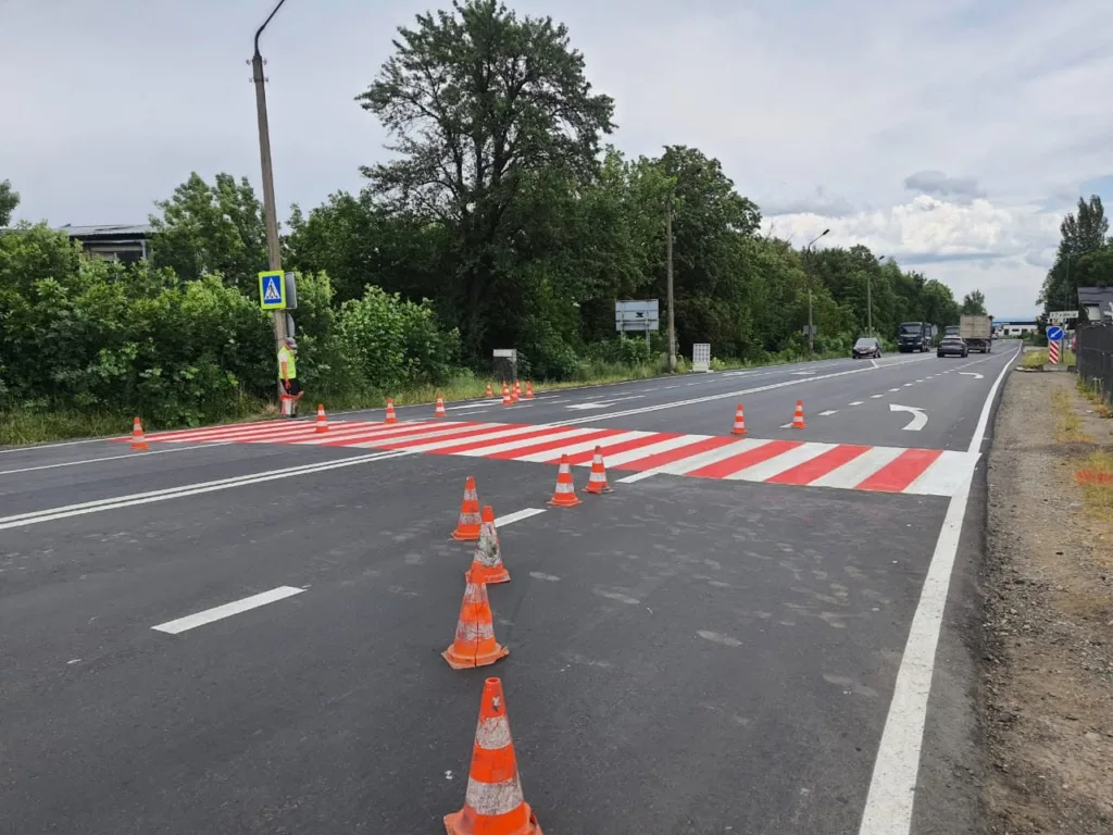 Нове пішохідне переходи з помаранчевими конусами на дорозі