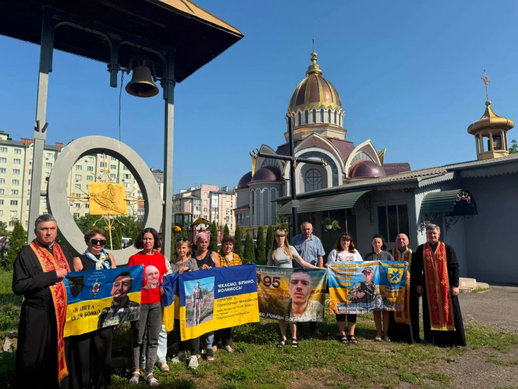 Люди з прапорами перед українською церквою