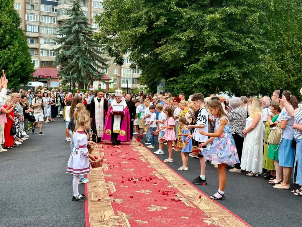 Релігійна процесія з дітьми та священником на вулиці